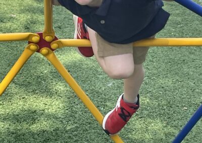 a young boy climbing on a playground structure